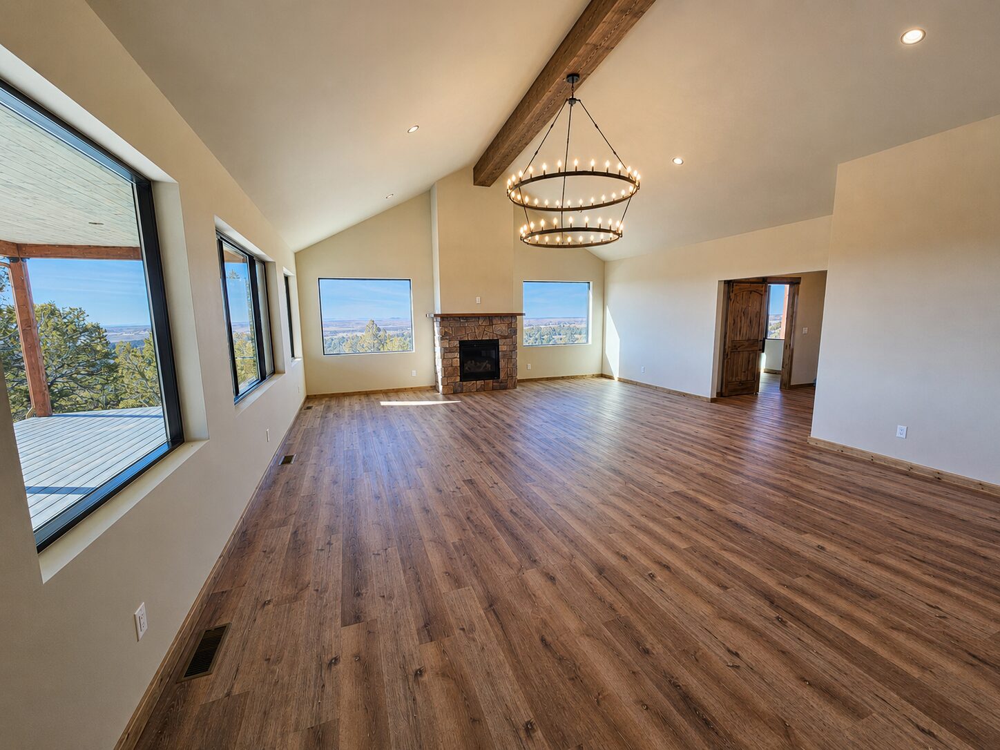 Vaulted living room with fireplace and chandelier